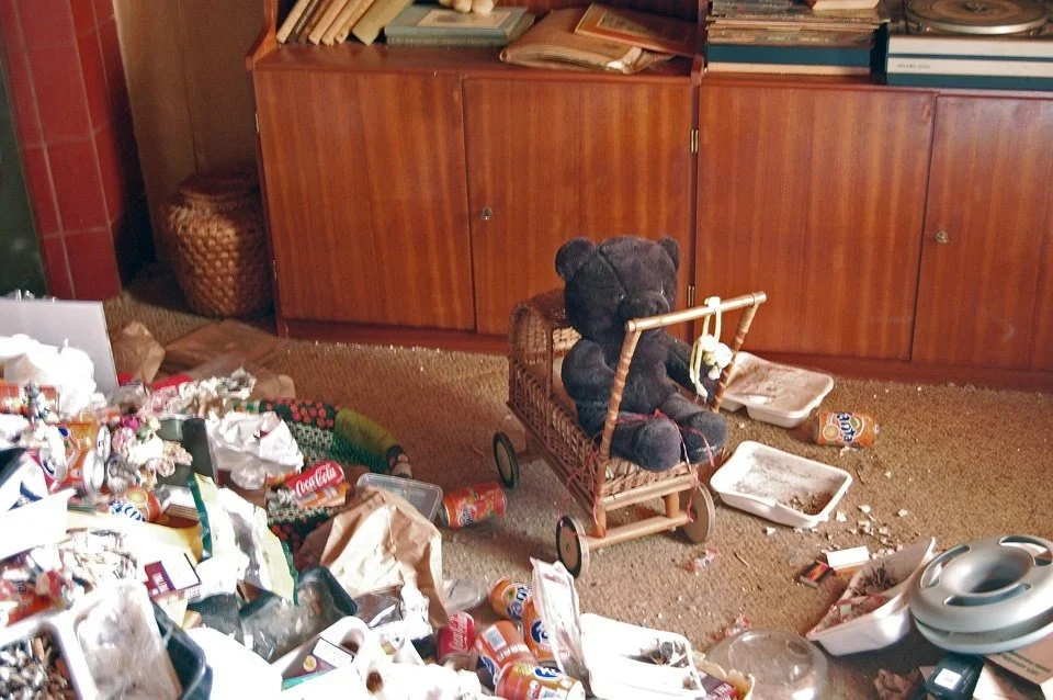 An armchair and belongings in an unoccupied home, from the Traces archive selection.