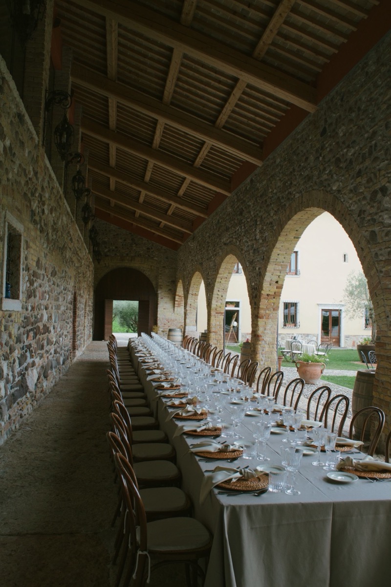 A long laid table under stone arches.